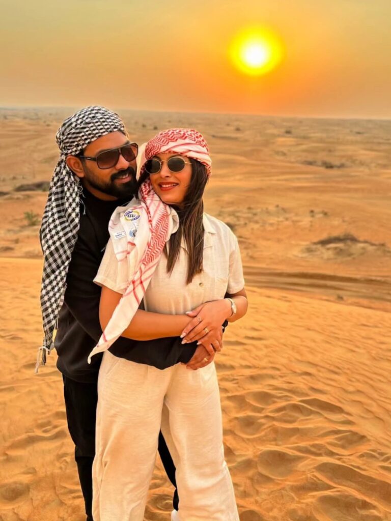 Couple in desert headscarves posing at sunset on a private safari