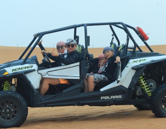 Family in a white 4-seater Polaris RZR 1000 buggy in the desert