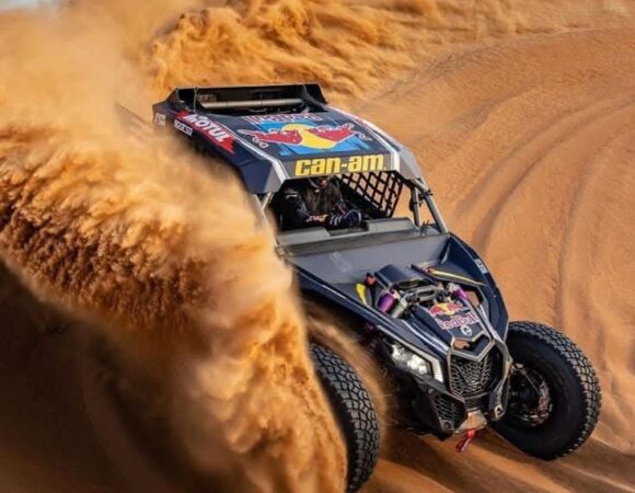 Can-Am Maverick buggy carving through a sand dune